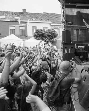 Le public lève les bras devant la scène lors d'un concert de Melfiano en plein air