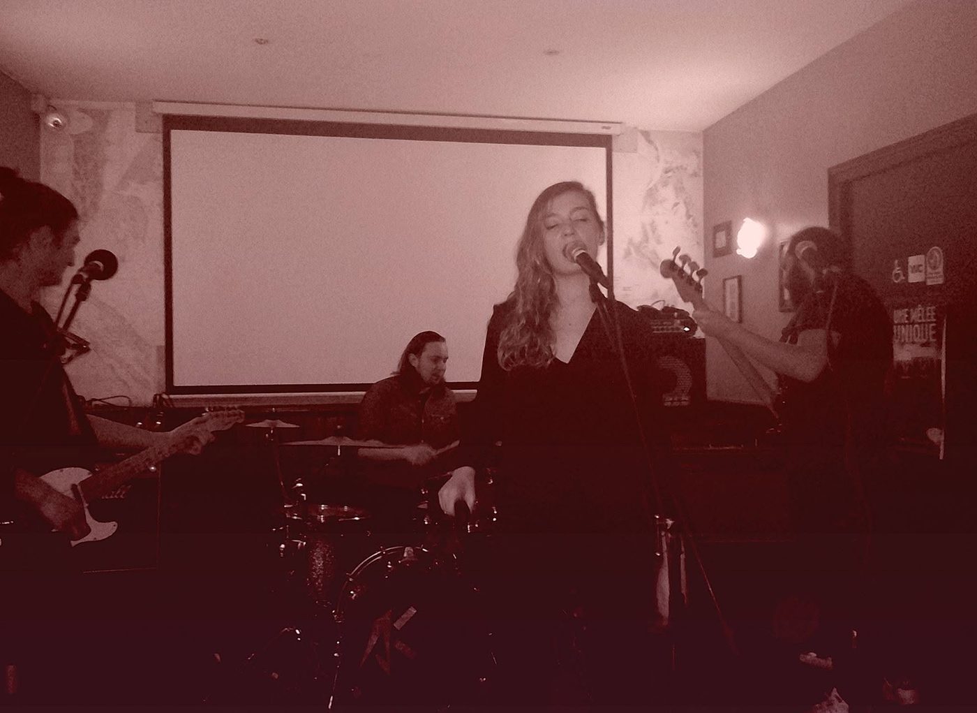 Shameless en concert dans un bar : la chanteuse au micro, entourée du guitariste, du batteur et du bassiste